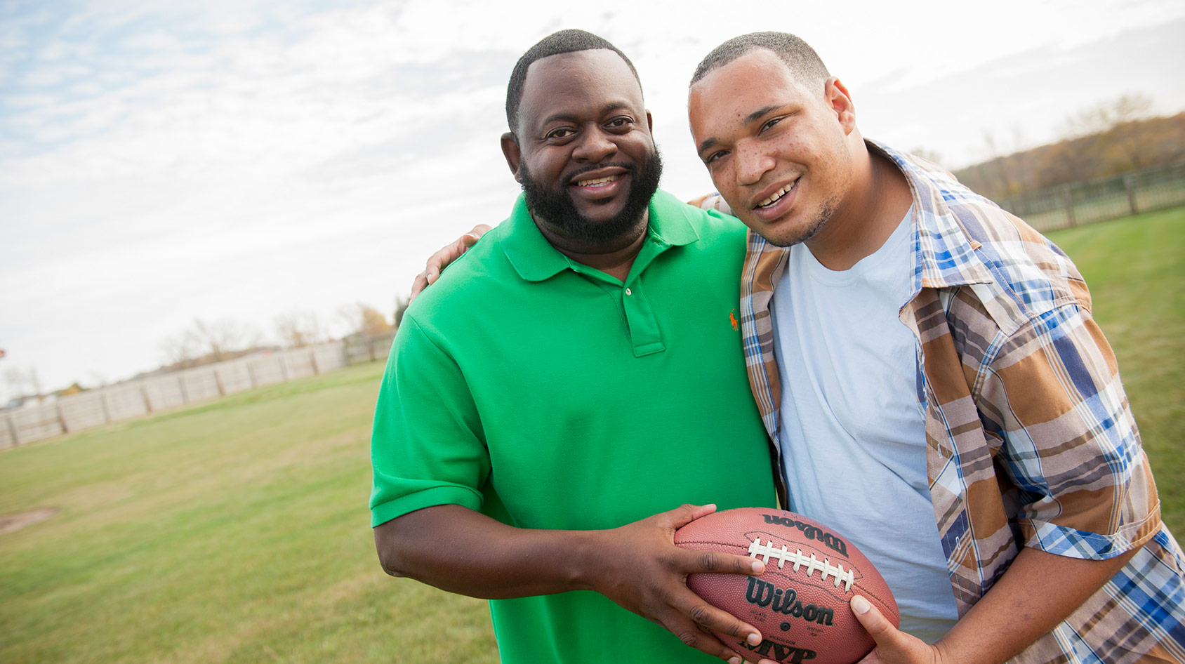 Two Men Smiling With Football