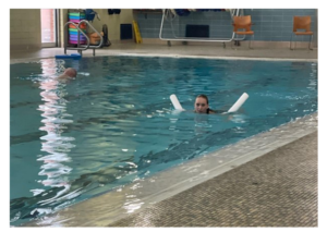 A young woman swims in an indoor swimming pool 